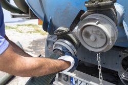 Homme connecte un tuyau sur un camion de débouchage de canalisations